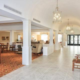 A spacious and elegantly decorated lobby with seating areas and chandeliers.