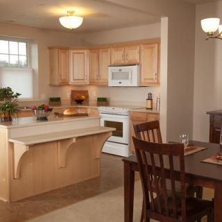A warm and inviting kitchen with wooden cabinets, a kitchen island, and a dining area.