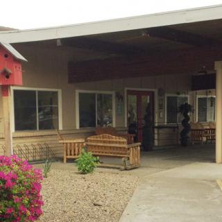 A welcoming building entrance featuring benches and colorful flowers.