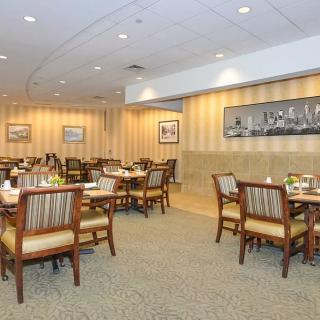 A spacious and well-lit restaurant dining area with neatly arranged tables and chairs.