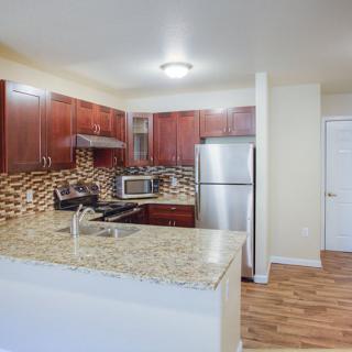 A modern kitchen featuring granite countertops and stainless steel appliances.
