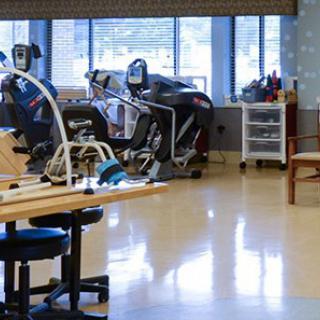 A physical therapy clinic with various exercise equipment and treatment areas.