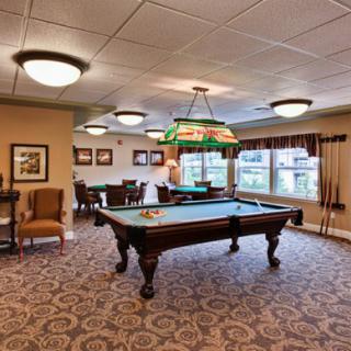 A well-decorated game room featuring a pool table and stylish lighting.