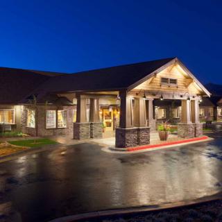A well-lit building entrance at night with a wooden structure and welcoming ambiance.
