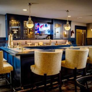 A modern bar interior featuring a sleek countertop, comfortable seating, and ambient lighting.
