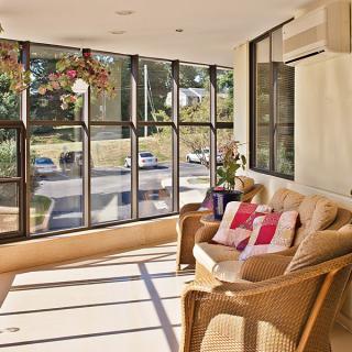 A cozy sunroom with wicker furniture and large windows letting in natural light.