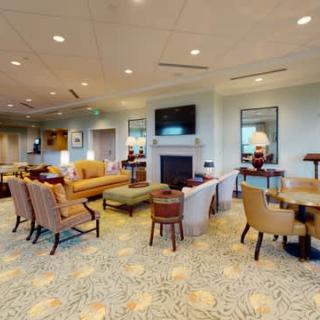 A spacious and well-furnished living room with comfortable seating, a fireplace, and a television.