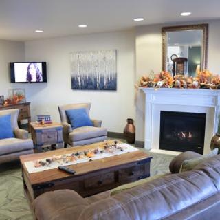 A cozy and inviting living room featuring comfortable seating, a TV, and a decorative fireplace.