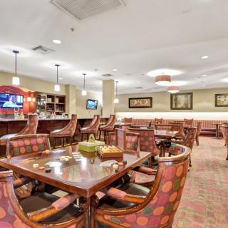 Interior view of a restaurant dining area with tables, chairs, and a bar.