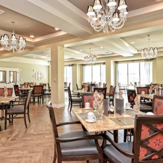 Elegant dining room interior with chandeliers and well-arranged tables.