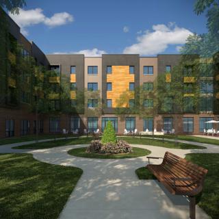 A modern apartment building with a landscaped courtyard featuring benches and a circular pathway.