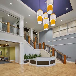 Modern lobby with a central staircase and stylish lighting.