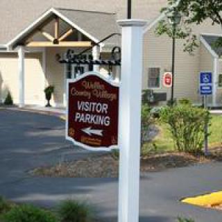 Visitor parking sign in front of a building entrance.