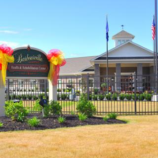 A welcoming entrance with a decorative sign and well-maintained landscaping.