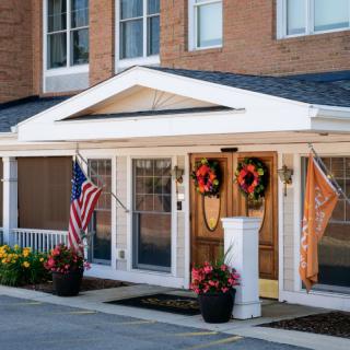 A decorated entrance with flags and wreaths on display.