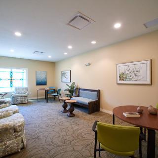 A cozy living room with comfortable seating, artwork on the walls, and a warm atmosphere.