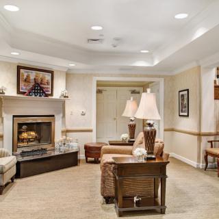A cozy living room featuring a fireplace, sofas, a coffee table, and elegant lighting.
