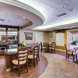 A well-lit dining area with tables and chairs arranged neatly.