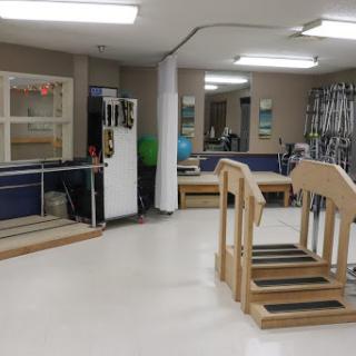 A physical therapy room equipped with various rehabilitation tools and walking aids.