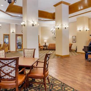 A spacious lobby featuring elegant chandeliers, comfortable seating, and a piano.