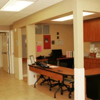 An office interior with desks and chairs arranged in a workspace.