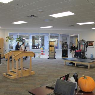 Interior view of a physical therapy center with exercise equipment and a pumpkin decoration.
