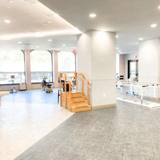 A bright and modern interior with an open layout featuring wooden stairs and plenty of natural light.