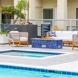 An inviting outdoor seating area by a pool with comfortable furniture and a modern design.
