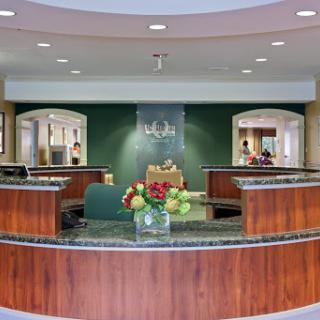 A welcoming reception area featuring elegant wooden furniture and floral arrangements.