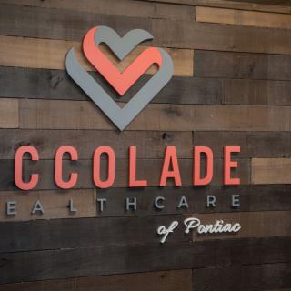 Accolade Healthcare logo on a wooden wall.
