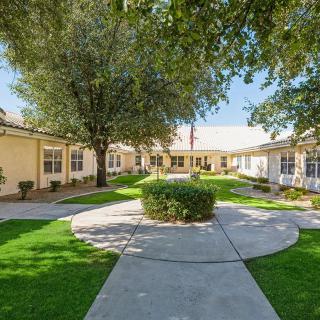 A serene courtyard with a circular walkway surrounded by buildings and lush greenery.