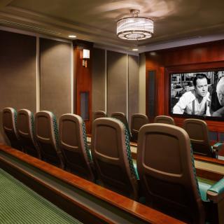 A luxurious home theater with comfortable seating and a classic movie playing on the screen.