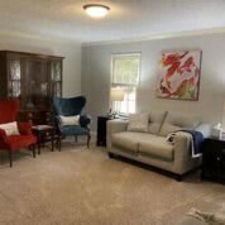 A cozy living room with a sofa, chairs, and decorative elements.