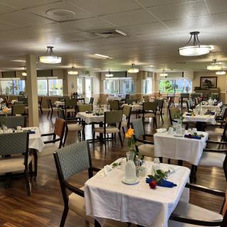 A spacious and elegantly set dining room with neatly arranged tables and comfortable seating.