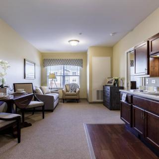 A cozy apartment interior featuring a living room with a kitchenette and dining area.