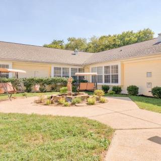 A sunny backyard with a patio and garden, featuring outdoor furniture and well-maintained landscaping.