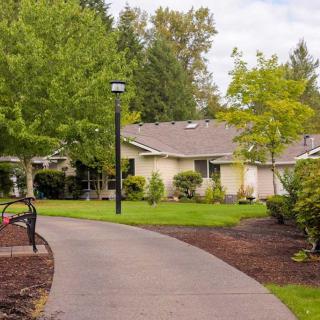 A peaceful residential house surrounded by lush greenery and a curved pathway.