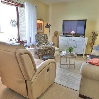 A cozy living room with comfortable seating, a television, and decorative elements.