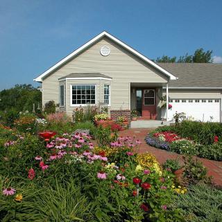 A charming house with a beautifully landscaped garden full of colorful flowers.