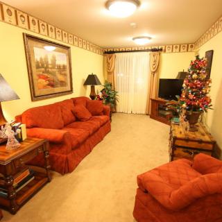 A cozy living room with orange sofas, decorative elements, and a television.