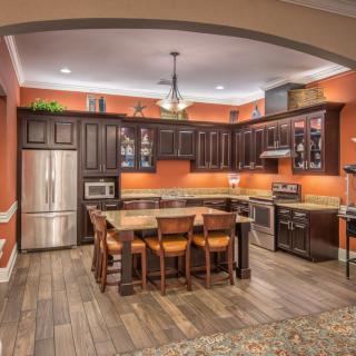A modern kitchen with wooden cabinets and stainless steel appliances, featuring an island counter.