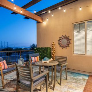 A cozy outdoor patio with seating, enhanced by warm string lights in the evening.