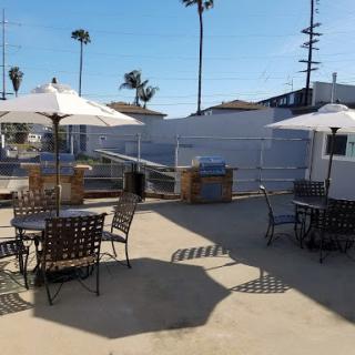 A sunny outdoor patio area featuring tables and umbrellas, perfect for enjoying the warm weather.