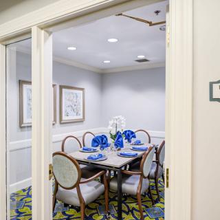 A small dining or meeting room with a table set for several people, featuring blue decorative elements.
