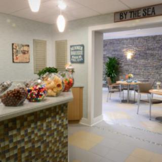 A modern and cozy interior featuring a reception area with snacks and a seating area in the background.