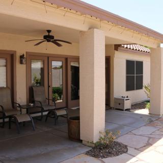 A cozy patio with outdoor seating and a ceiling fan for relaxation.