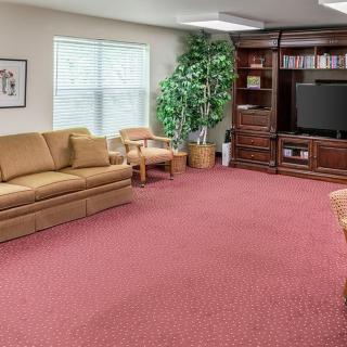 A cozy living room with a sofa, television, and bookshelf.