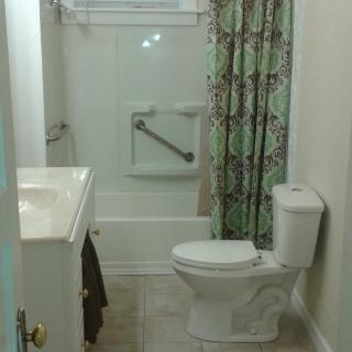A small bathroom with a toilet, sink, and shower curtain.