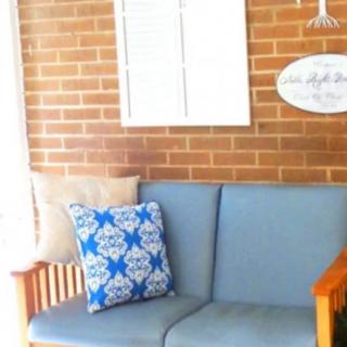 A cozy seating area with a blue cushioned sofa against a brick wall.