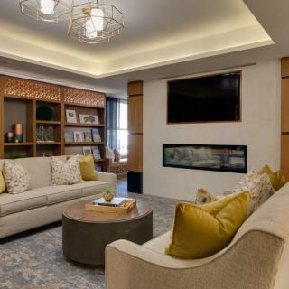 A modern living room with cozy seating, a fireplace, and elegant lighting.
